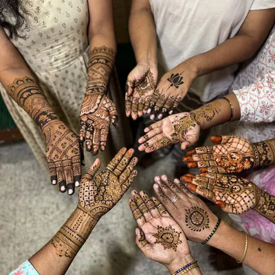 A circle of joy! This photo shows the variety of designs our team created for guests at a single event, from full-palm patterns to simpler motifs.