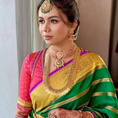 A portrait of modern South Indian elegance. The makeup is focused on creating a flawless base, with defined eyes and a warm lip color that complements the vibrant hues of her Gaurang saree.