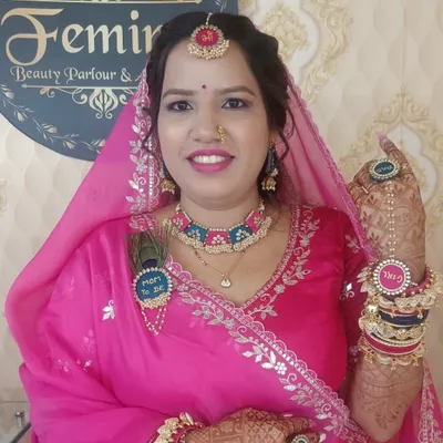 A beautiful look for a `Godh Bharai` or baby shower. The client is glowing in a traditional pink Marwari outfit, with "Mom to be" accessories and fresh, happy makeup.