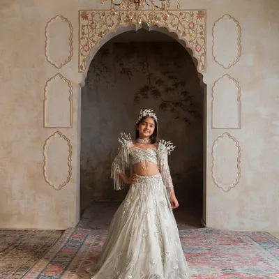 The centerpiece of our collection, this antique green lehenga features stunning pearl and crystal work on the sleeves and a matching choker. It’s a regal choice for a flower girl or a star at a family wedding.