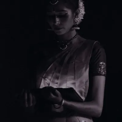 A quiet moment of reflection just before going on stage. The makeup is done, the costume is on, and the mind is focused. This is the calm before the energy of the performance is unleashed.