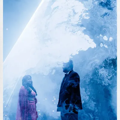 A creative double exposure from a Sangeet night. We blended a portrait of the couple with the smoky, ethereal blue lighting of their stage performance to create a unique and artistic memory of their celebration.