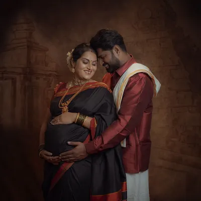 A tender moment shared between partners. The dark, textured backdrop makes the subjects stand out, creating a classic, painting-like feel for this couple's maternity portrait.