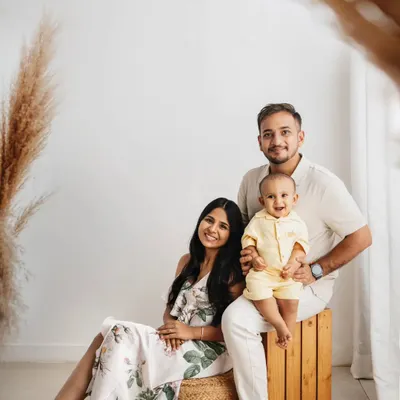 A first birthday portrait in my boho studio setup. The natural wood and pampas grass complement the family's neutral outfits perfectly.
