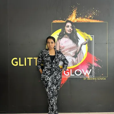 Standing proud next to my brand logo at my studio. This space was my creative hub, and while I'm transitioning away from a physical teaching space for now, my work as a makeup artist continues.