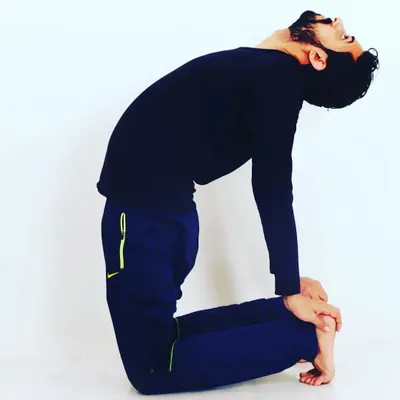 This is a variation of Ustrasana, or Camel Pose, a deep backbend that opens the entire front of the body. I practice advanced poses like this to maintain my own flexibility and strength.
