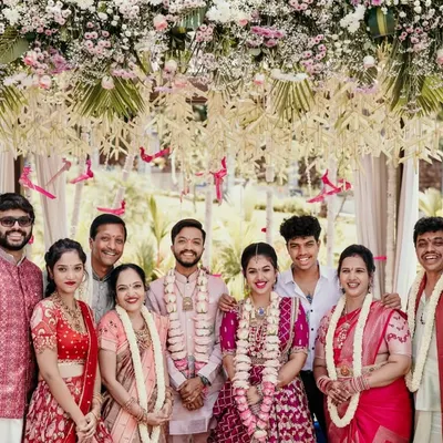 A classic group portrait of a large family gathered under a beautiful floral arch. Posed multi-generational photographs like this are essential for remembering who was there to share in the joy.