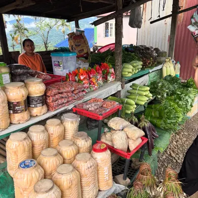 A glimpse into a farmers' market in Nagaland, where we source many of our ingredients. You can see jars of fermented bamboo shoot, fresh Raja Mircha, and local greens being sold by the women who grow them.
