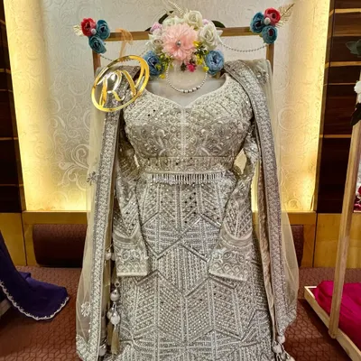 A close-up of this stunning silver lehenga, packed and ready for a bride's trousseau. I used a mannequin form to display its intricate work and added a floral garland and a custom initial tag for a complete look.