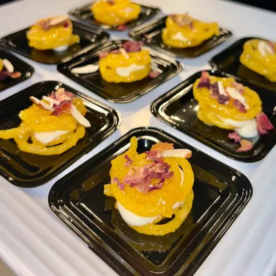My Rabdi Jalebi is a heavenly fusion of two classics. A crispy, syrup-soaked jalebi is filled with rich and creamy rabdi, then garnished with almonds and rose petals.