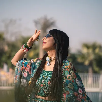 A stylish shot of the bride enjoying the sun during her outdoor Mehandi function. Her modern, colorful outfit and sunglasses give this a fun, festive vibe.