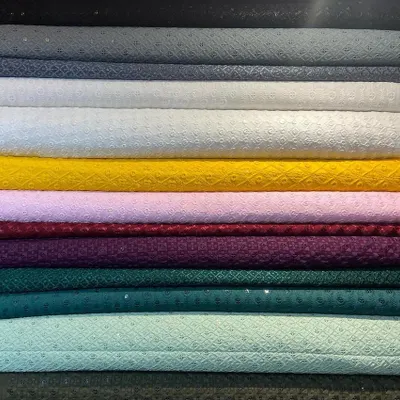 A stack of pure Chikankari fabrics, showcasing the range of colors I offer for bespoke kurtas. This traditional hand-embroidered textile from Lucknow is a popular choice for its elegance and breathability.