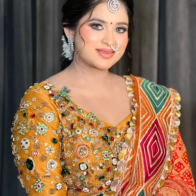 A beautiful portrait of a bride ready for her cocktail event. The makeup is soft and glowing, with a traditional maang tikka.