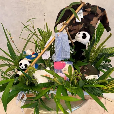 For this unique baby announcement, the brief was a panda jungle. I used real bamboo, lush foliage, and curated items like a camouflage jacket and panda toys to create a truly immersive and memorable gift.