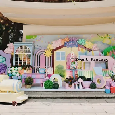 A full stage setup for Taashvi's Peppa Pig party. This vibrant and playful world includes Peppa's house, a colorful train, and cutouts of Peppa and her family, all in a cheerful pastel palette.
