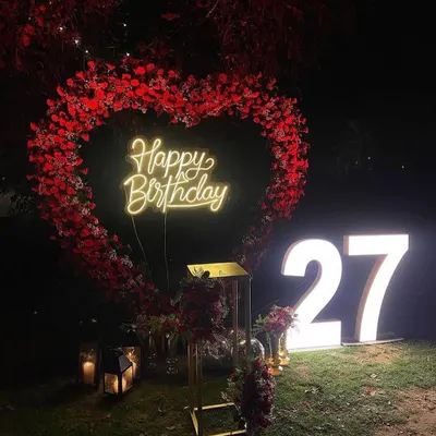This large heart-shaped floral arch creates a perfect backdrop for a surprise proposal. Paired with a custom neon sign and soft lighting, it makes for a very romantic and photogenic moment.
