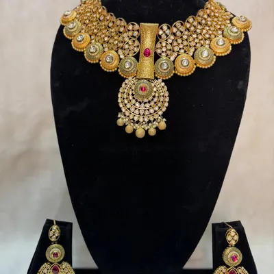 This is my bridal set B-15, which has a beautiful antique gold finish. The design features a central pendant with red stone and large, ornate matching earrings.