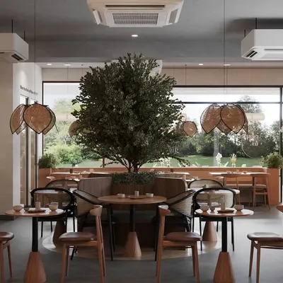 The main dining area is defined by a large, beautiful tree that brings life and tranquility to the space. We used a mix of chair styles, including rattan and wood, to add visual interest while maintaining a cohesive, nature-inspired theme.