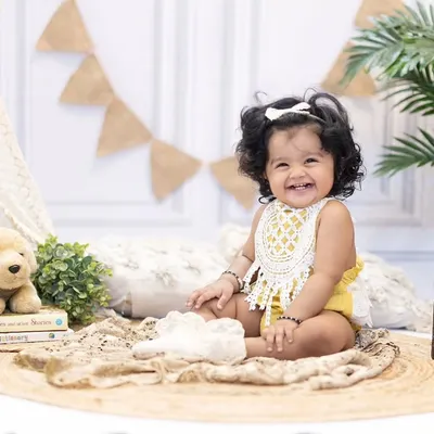 That smile says it all. This happy little girl is celebrating her first birthday with a fun, boho-themed studio session.