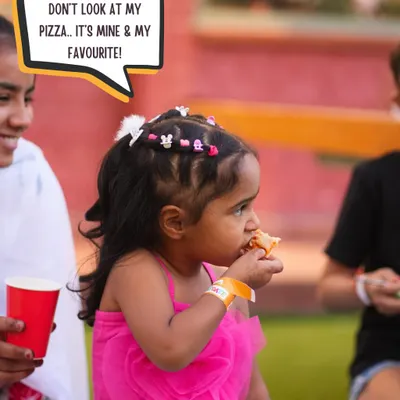 A little guest enjoying her favorite slice of pizza. Our party food is always a hit with the kids.