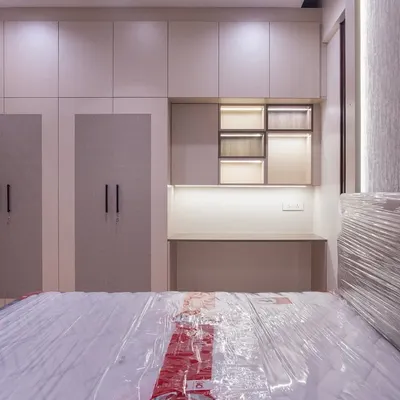 For this guest bedroom, I designed a wardrobe unit that includes an integrated desk and open shelving with backlighting. This creates a cozy, functional corner for guests to work or unwind without cluttering the room.