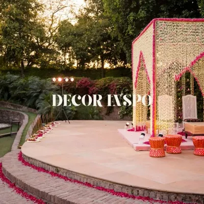 A stunning mandap decorated with strings of white and pink flowers, set in the beautiful outdoor amphitheater of Zorba, Delhi. This is decor inspiration at its finest.