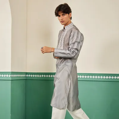 The pearl grey Chanderi silk kurta in motion, showing its elegant drape and the intricate white embroidery on the sleeves.