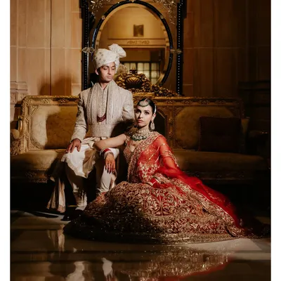 A portrait that exudes royalty. Amala and Aditya are framed by the opulent interiors of the Umaid Bhawan Palace, a perfect blend of regal attire and a majestic setting.