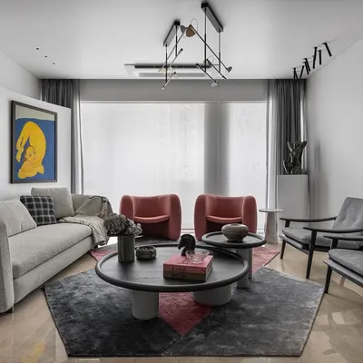 A luxuriously layered living room where art is the hero. The neutral sofa and geometric rug provide a sophisticated base for the bold yellow artwork and sculptural pink chairs, creating a space that is vibrant and full of personality.