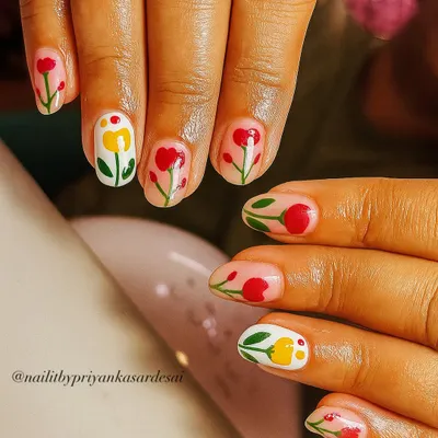 A garden party on your nails. This adorable set on short, natural nails features hand-painted red and yellow tulips against a sheer nude base for a fresh and playful look.
