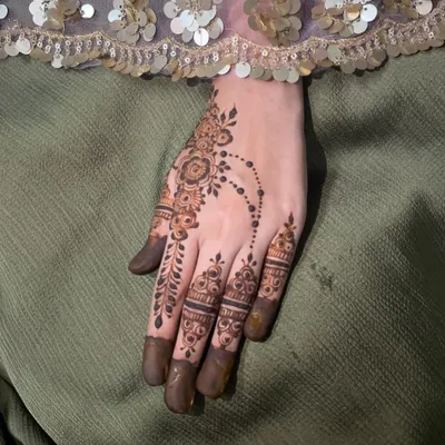 A delicate vine of henna that trails down one finger, with simple bands on the others. This is a perfect example of a minimal party design.