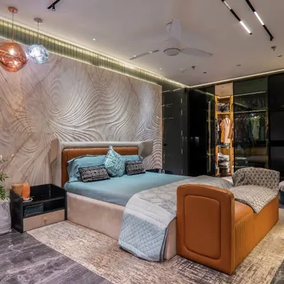 This bedroom features a stunning 3D carved accent wall that creates a sense of movement and artistry. The design is complemented by warm, ambient lighting, a custom leather bench, and rich, dark flooring for a truly unique and luxurious feel.