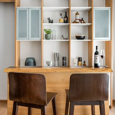 For the 'Pepper and Coffee' project, we designed this custom bar and shelving unit with a live-edge wood counter, creating a perfect spot for entertaining.