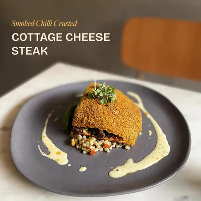 Back on the menu by popular demand. This is our Smoked Chili-Crusted Cottage Cheese Steak, stuffed with olives and sun-dried tomatoes, served on Israeli couscous with a jalapeño cheese fondue.