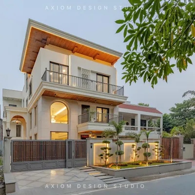 A look at our completed neoclassical home at dusk. The design features grand arches, a balanced composition, and warm, layered lighting that highlights the stone cladding and wooden soffit, creating a welcoming and sophisticated presence.