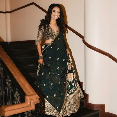 A glowing and gorgeous bride making her entrance. For her reception, we chose a stunning dark green and gold lehenga, paired with soft waves and a luminous makeup look.