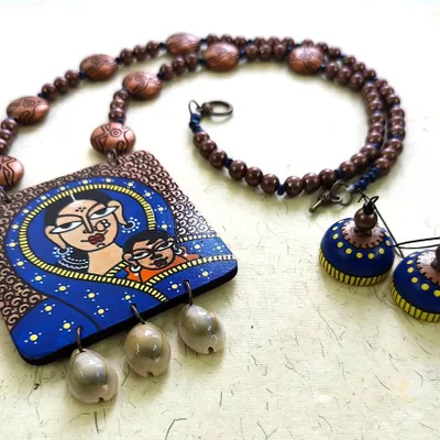 A different view of the 'Mamta' necklace set, celebrating the unbreakable bond between a mother and child. The hand-painted details are paired with earthy beads and delicate shells.