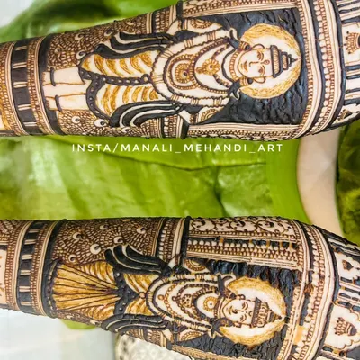 A close-up of the Lord Vitthal and Rukmini portraits from a devotional mehandi design. The dark henna application makes the divine figures stand out beautifully.