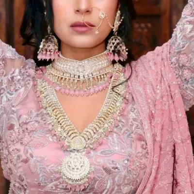 This pastel pink lehenga with intricate silver embroidery is a popular choice for engagement ceremonies. It's paired here with a matching pink-beaded choker and rani haar set.
