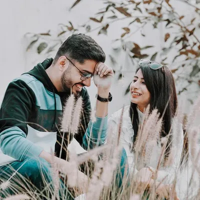 A lighthearted moment during a pre-wedding shoot where the couple shares a laugh. I used the natural foliage to frame them, creating a soft and romantic atmosphere for this candid couple portrait.