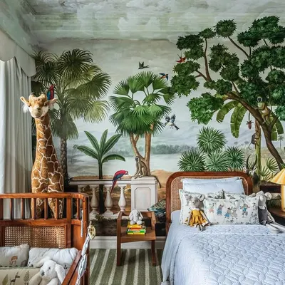 A complete view of this jungle-themed nursery, showing how the crib and toddler bed work together in the space. The hand-painted mural wraps around the room, creating a truly immersive and adventurous world for a little one.