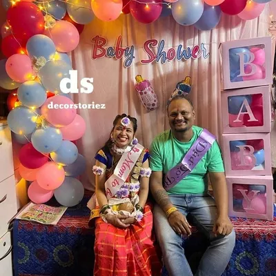 A happy couple at their baby shower celebration. I create beautiful photo backdrops like this one, complete with sashes for the 'Mom to be' and 'Dad to be'.
