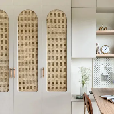 Storage can be beautiful. These custom wardrobes feature arched panels with cane webbing, combining a light, natural texture with the clean lines of modern cabinetry.