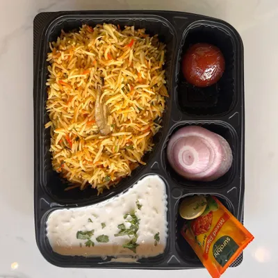 Our customizable meal boxes are ideal for corporate lunches or events. This box features a delicious vegetable biryani, raita, gulab jamun, and onion salad, providing a complete and satisfying meal.