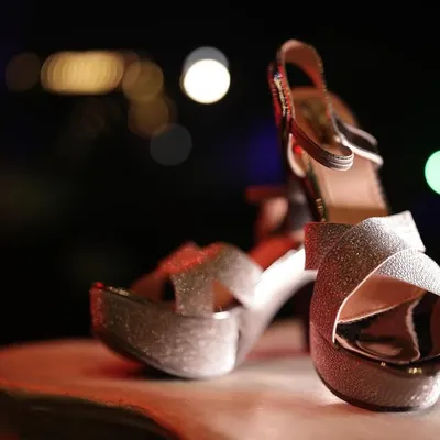 A beautifully lit, artistic shot of the bride's sparkling wedding heels, capturing the glamour and detail of her accessories.