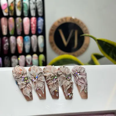 This is advanced 3D nail art. We teach our students how to sculpt these incredibly detailed, multi-layered flowers with rhinestone centers for a truly show-stopping effect.