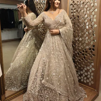 A stunning pre-loved lehenga in a sophisticated beige tone. The full-length view shows the beautiful flare and the all-over sequin and thread work, perfect for a reception.