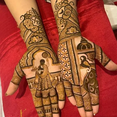 A classic Karwa Chauth design featuring a woman looking at the moon through a sieve. The other hand showcases a majestic peacock, blending traditional symbols of love and beauty.