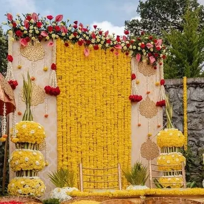 A classic haldi ceremony backdrop featuring a wall of bright yellow marigolds. I added hanging floral strings (latkans) and tiered floral stands to create a traditional and festive look, perfect for capturing the joy of the ceremony.