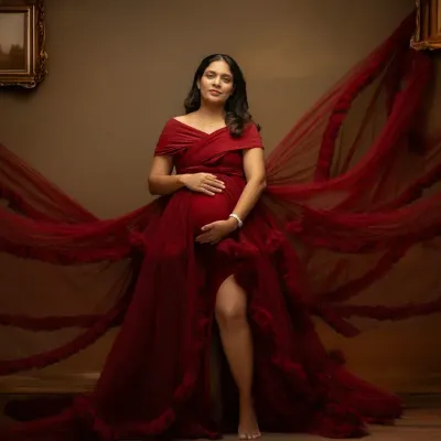 A powerful portrait in a magnificent red gown. The flowing fabric creates a sense of motion and drama, perfectly highlighting the beauty of the baby bump in this studio maternity photo.